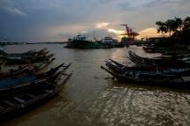 The sun sets as small ferry boats dock near a jetty of Yangon river, Yangon, Myanmar. Photo: Lynn Bo Bo/EPA