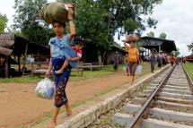 A photo made available on 22 July 2015 shows flood victims of Kan Gyi village receive aid from locals at the Kan Gyi railway station in Kanbalu, Sagaing Division, Myanmar, 21 July 2015. Photo: Pyae Sone Aung/EPA
