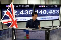 A monitor (R) displays the current exchange rate of the Japanese yen against the British Pound as a trader works at a foreign exchange brokerage in Tokyo, Japan, 24 June 2016. Photo: Franck Robichon/EPA
