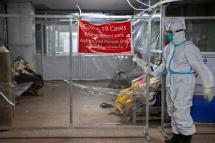 A medical worker wearing PPE (personal protective equipment) walks into the COVID-19 cases management zone at the emergency department of Yangon General Hospital, Yangon, Myanmar, 01 January 2021. Photo: Lynn Bo Bo/EPA
