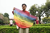 An activist holds a rainbow flag, a symbol of LGBT pride and LGBT social movements, in the courtyard of India’s Supreme Court in New Delhi on October 17, 2023 / Photo: AFP