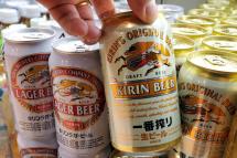 A customer picking up a can of Kirin beer at a liquor shop in Tokyo, Japan. Photo: Kimimasa Mayama/EPA
