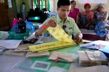 (File) A staff member of the election commission prepares ballot at a polling station in the Wai Maw township of the Ma Khan Di village, Kachin State, northern Myanmar, 06 November 2015. Photo: EPA