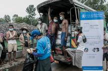 In this photo taken on May 21, 2021, people wait to receive bags of rice distributed by the World Food Programme (WFP) as part of food aid efforts to support residents living in poor communities on the outskirts of Yangon. Photo: AFP