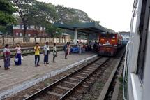 Passengers wait for the commuter train in Yangon. Photo: EPA