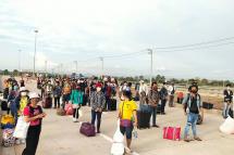 Myanmar citizens return from Thailand queue at the Myawady border on 26 May. Photo: MNA