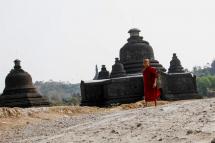 A young Buddhist novice walks past ancient pagodas at Mrauk U of Rakhine State, western Myanmar. Photo: Nyunt Win/EPA