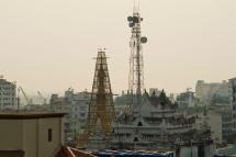  In this photograph taken on February 25, 2016, a telecom tower (R) is seen near the bamboo scaffolding-clad Sule pagoda tower (L) in Yangon. Photo: AFP