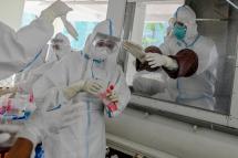 Medical staff prepare materials for COVID-19 coronavirus test at a quarantine facility in Hlaing University in Yangon. Photo: AFP