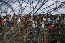 Rohingya refugees gather behind a barbed-wire fence in the “no-man’s land” border zone between Myanmar and Bangladesh, April 25, 2018. Photo: Ye Aung Thu/AFP