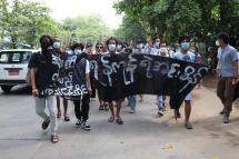 This photo taken and received courtesy of an anonymous source via Facebook on April 29, 2021 shows protesters marching with banners as they take part in a demonstration against the military coup in Insein township in Yangon. Photo: AFP