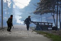 (File) Soldiers patrol past burning houses amid ongoing violence in Sittwe, capital of Myanmar's western state of Rakhine, on June 12, 2012. Photo: AFP