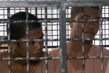 Two Myanmar migrant workers  accused of the killing of two British tourists Wai Phyo (L) and Zaw Lin (R) sit behind bars of a prison vehicle as they arrive for trial at a court on Samui island 8 December 2014. Photo: Sitthipong Chareonjai/EPA
