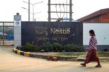 A woman walks in front of the Nestle factory gate at Dagon Seikkan Industrial Zone in Yangon on February 28, 2023. Photo: AFP