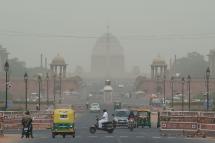 Vehicles pass by the Indian President house as dust covers the skyline in New Delhi. Photo: AFP