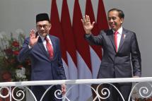 Indonesian President Joko Widodo (R) and Malaysia's new Prime Minister Anwar Ibrahim (L) wave to journalists during their meeting at the Presidential Palace in Bogor, Indonesia, 09 January 2023. Photo: EPA