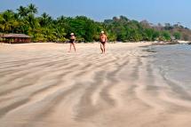 Foreign tourists walk along Ngapali beach, on the Bay of Bengal, west coast of Myanmar. Photo: EPA