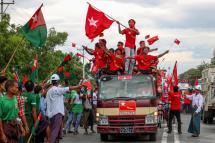 Supporters of the National League for Democracy (NLD) party on a motorcade pass supporters of the opposition Union Solidarity and Development Party (USDP), seen at left, during a campaign in Wundwin, near Mandalay on September 19, 2020. Photo: AFP