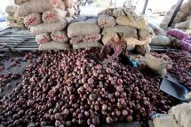 An Indian laborer sorts onions at a wholesale vegetable market in Jammu, India, 02 December 2019. Photo: EPA