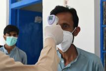A doctor checks the temperature of a man on February 25 as he returns from Iran to Pakistan, where two cases of novel coronavirus have been confirmed (AFP Photo/Banaras KHAN) 