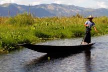 A villager from Inle Lake rows a boat with his leg in Shan State. Photo: EPA