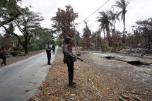 Myanmar policemen look at Myo Thu Gyi Muslim village where houses were burnt to the ground near Maungdaw town in northern Rakhine State on August 31, 2017. Photo: AFP
