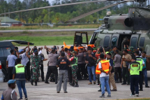 Indonesian police and military officers transfer victim's bodies from a helicopter to an ambulance in Timika on July 16, 2022. Photo: AFP