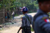 Rohingya Muslims in the village of Shwe Zarr looking at Myanmar police, who are providing security due to recent nearby unrest, near Maungdaw township in Rakhine State. Photo: AFP
