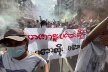 Demonstrators holding posters and flares as they march during an anti-military coup protest at downtown area in Yangon, Myanmar, 03 July 2021.  Photo: EPA
