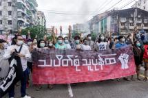 Protesters make the three-finger salute as they take part in a flash mob demonstration against the military coup in Yangon.  Photo: AFP