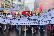  This photo taken and received courtesy of an anonymous source via Facebook on June 26, 2021 shows protesters marching with banners and flares as they take part in a demonstration against the military coup in Yangon. Photo: AFP