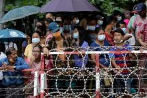 People wait behind barricades for their relatives to be released outside the main entrance of Insein prison compound in Yangon, Myanmar, 30 June 2021. Photo: EPA