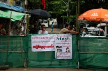 Myanmar men wait behind fence blocking access to the street with the sign reading 'Stay-at-Home, No outsiders are allowed', Yangon, Myanmar, 12 September 2020. Photo: Lynn Bo Bo/EPA