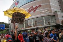 Supporters of Malaysian opposition leader Anwar Ibrahim hold up an umbrella with a placard reading: 'Undur Najib (Step down Najib)' during a 'Kita Lawan' (Fight Back) rally in Kuala Lumpur, Malaysia, March 7, 2015. Photo: Fazry Ismail/EPA 
