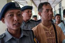 (File) Swe Win (C), the editor of Myanmar Now, is escorted to a court by police in Mandalay on July 31, 2017 a day after he was detained by police at Yangon airport as he tried to fly to Bangkok under a controversial law often wielded against the press. Photo: AFP
