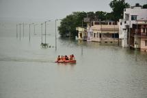 Members of National Disaster Response Force (NDRF) ride in an inflatable boat as part of a rescue operation in a flooded area in Allahabad on August 12, 2021, as thousands of stranded Indians were rescued from flooded villages along the Ganges after the river rose above its danger level in the country's most populous state.  Photo: AFP