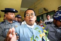 Dr Aye Maung (C), Ann Township MP and former Arakan National Party leader, talks to members of the media while being escorted out of court by police officers after a hearing on his trial at Sittwe court, in Sittwe, Rakhine State, western Myanmar, 13 August 2018. Photo: Nyunt Win/EPA