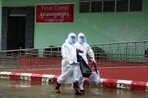 Medical workers wearing PPE (Personal protective equipment) walk past the Fever Corner of a hospital in Sittwe, Rakhine State, western Myanmar, 24 August 2020. Photo: Nyunt Win/EPA