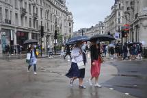 Shoppers shelter under umbrellas on a wet day in London, Britain 04 June 2021.  Photo: EPA