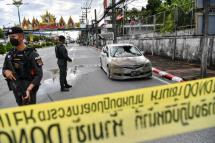 Police officials stand near a partly damaged car, after a car bomb exploded outside a police accommodation in Narathiwat town, southern Thailand, on November 22, 2022. One person died and more than two dozen were injured in the attack, the provincial governor said. Photo: AFP