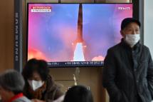 People watch a television screen showing a news broadcast with file footage of a North Korean missile test, at a railway station in Seoul on November 2, 2022. South Korea on November 2 told residents on the island of Ulleungdo off its east coast to evacuate to bunkers after North Korea fired three short range ballistic missiles. Photo: AFP