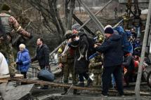 Ukrainians have been crossing what remains of a destroyed bridge to reach Kyiv. Photo: AFP