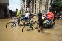 Rickshaw riders at work on an inundated street in Sylhe, Bangladesh, amid floods that have left at least 57 dead in the country and India. Photo: AFP