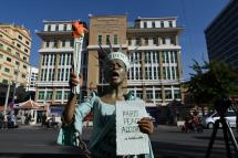 Cambodian-American human rights advocate Theary Seng, dressed as Lady Liberty, shouts slogans in front of Phnom Penh municipal court on June 14, 2022. Photo: TANG CHHIN Sothy / AFP