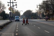 People cross a road in Xi'an in China's northern Shaanxi province on December 31, 2021, amid a Covid-19 coronavirus lockdown. (AFP/STR)
