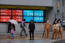 People stand in front of an electronic quotation board displaying the closing numbers of share price at the Tokyo Stock Exchange in Tokyo, May 17, 2021. Photo: AFP