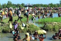 In this file photo taken on 16 October, 2017, Rohingya refugees walk through a shallow canal after crossing the Naf River as they flee violence in Myanmar to reach Bangladesh. Photo: AFP