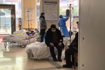 Covid-19 coronavirus patients rest on hospital beds in the lobby of the Chongqing No. 5 People's Hospital in China's southwestern city of Chongqing on December 23, 2022. (Photo by Noel CELIS / AFP)