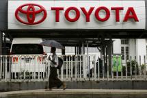A man walks past a motor parts and services shop with Toyota logo in Yangon, Myanmar, 27 May. Photo: EPA