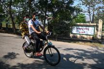 A person wearing a face mask as a preventive measure against the COVID-19 novel coronavirus, rides past Waibagi Hospital in Yangon that handles patients for isolation on March 24, 2020. Photo: Ye Aung Thu/AFP
